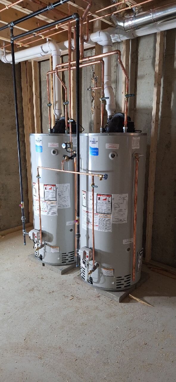 Two Bradford White water heaters with copper piping installed in a basement