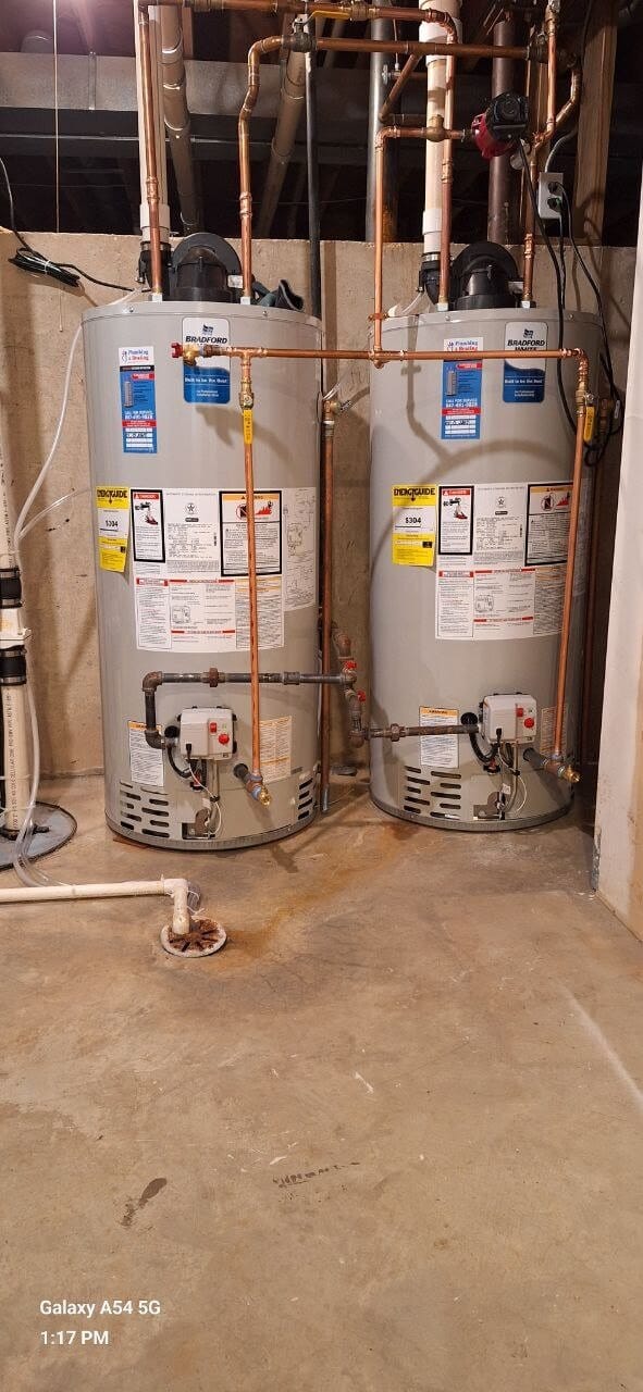 Two Bradford White gas water heaters with copper piping in a basement