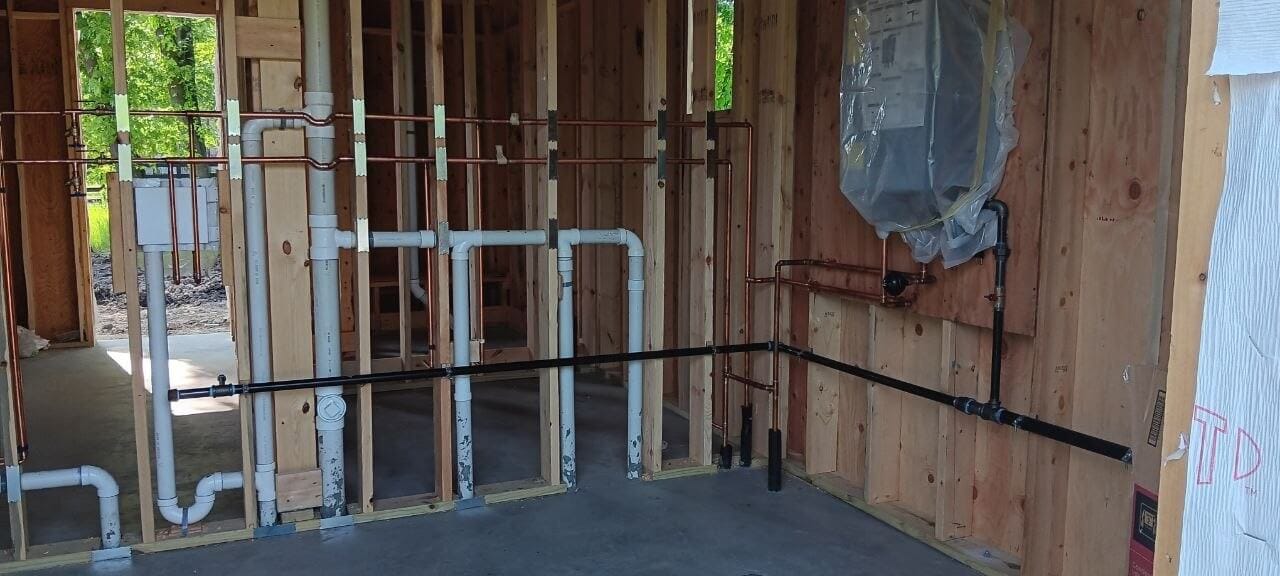 PVC drain and vent rough-in piping in a framed wall