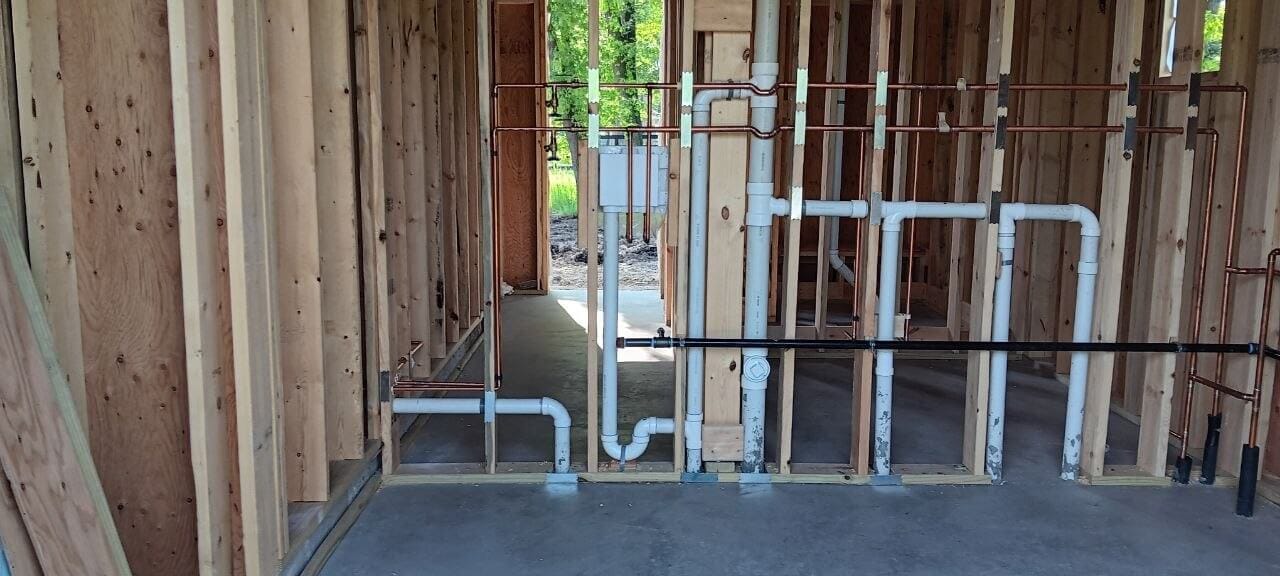New drain, vent, and gas rough-in piping installed in a framed wall