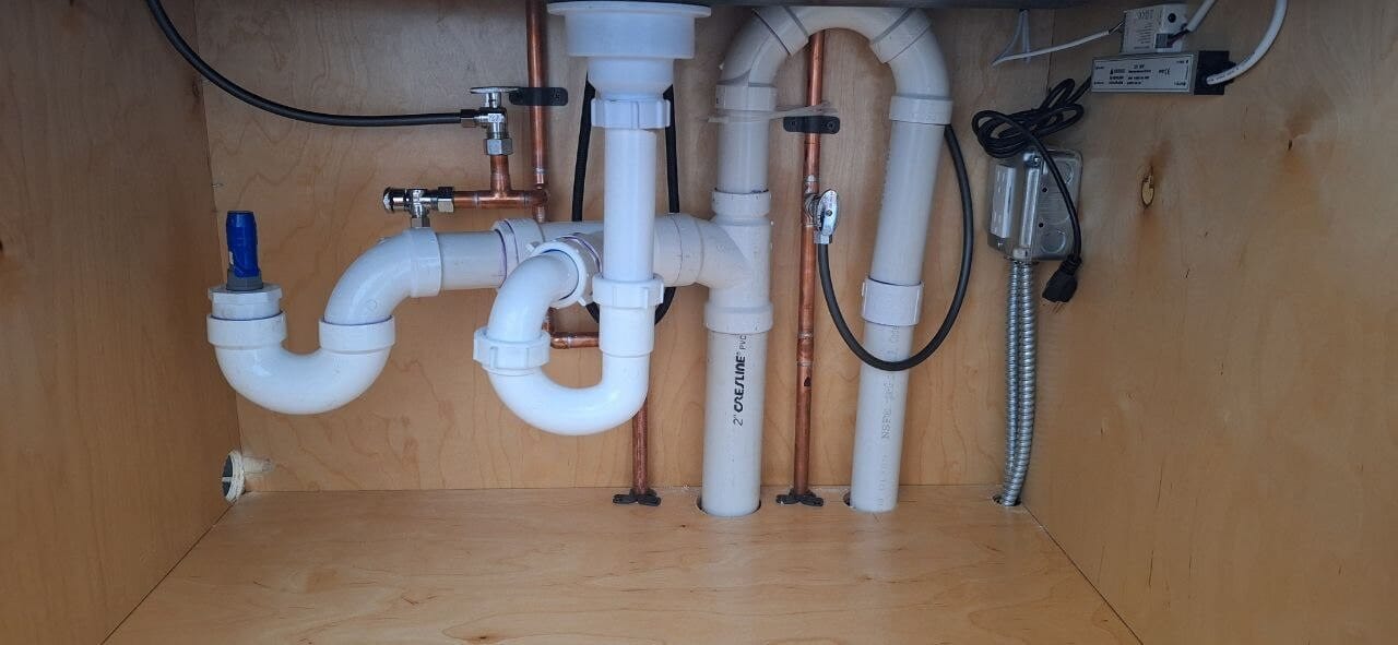 Sink drain lines and P-traps installed under a cabinet