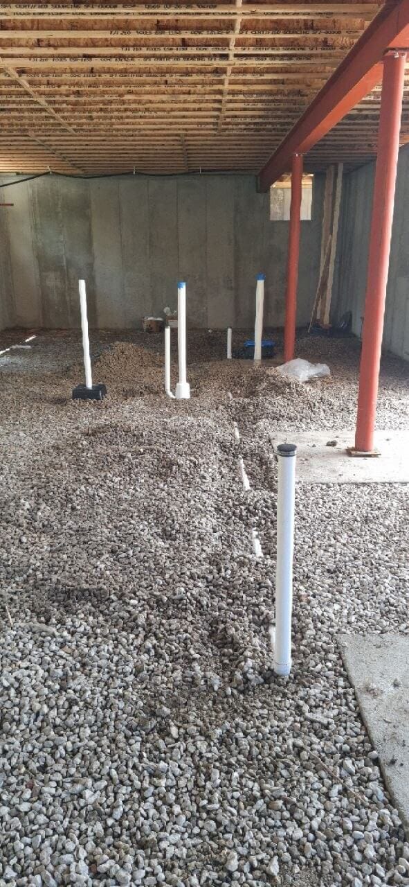 Under-slab plumbing rough-in with vent stubs in a new basement